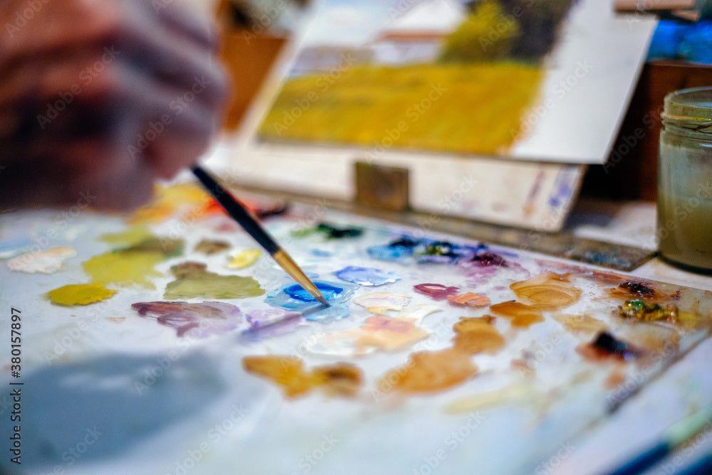 An artist mixing color at the palette — process and material study